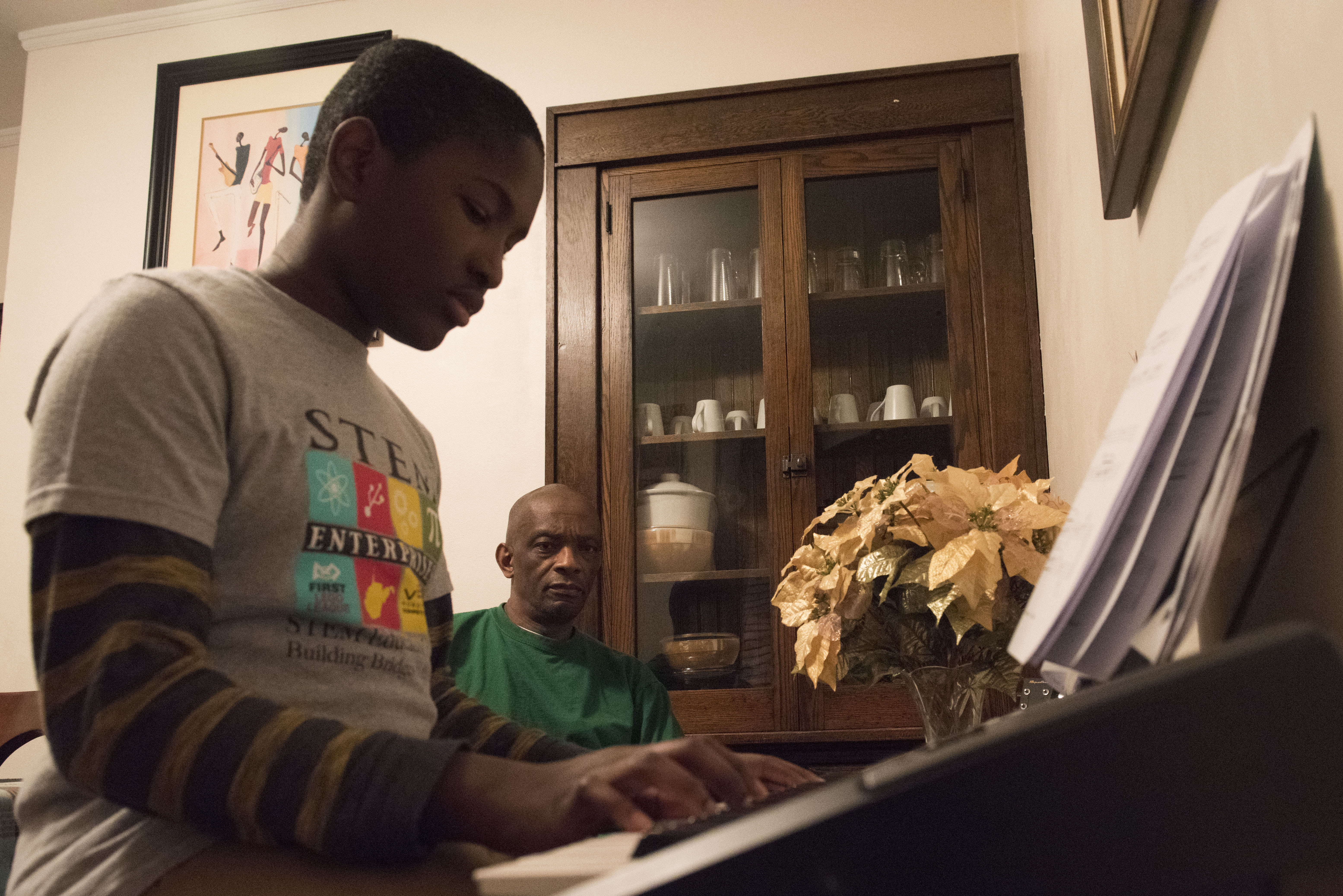 In their dining room, Tamba watches his son play piano which he has been practicing for years.